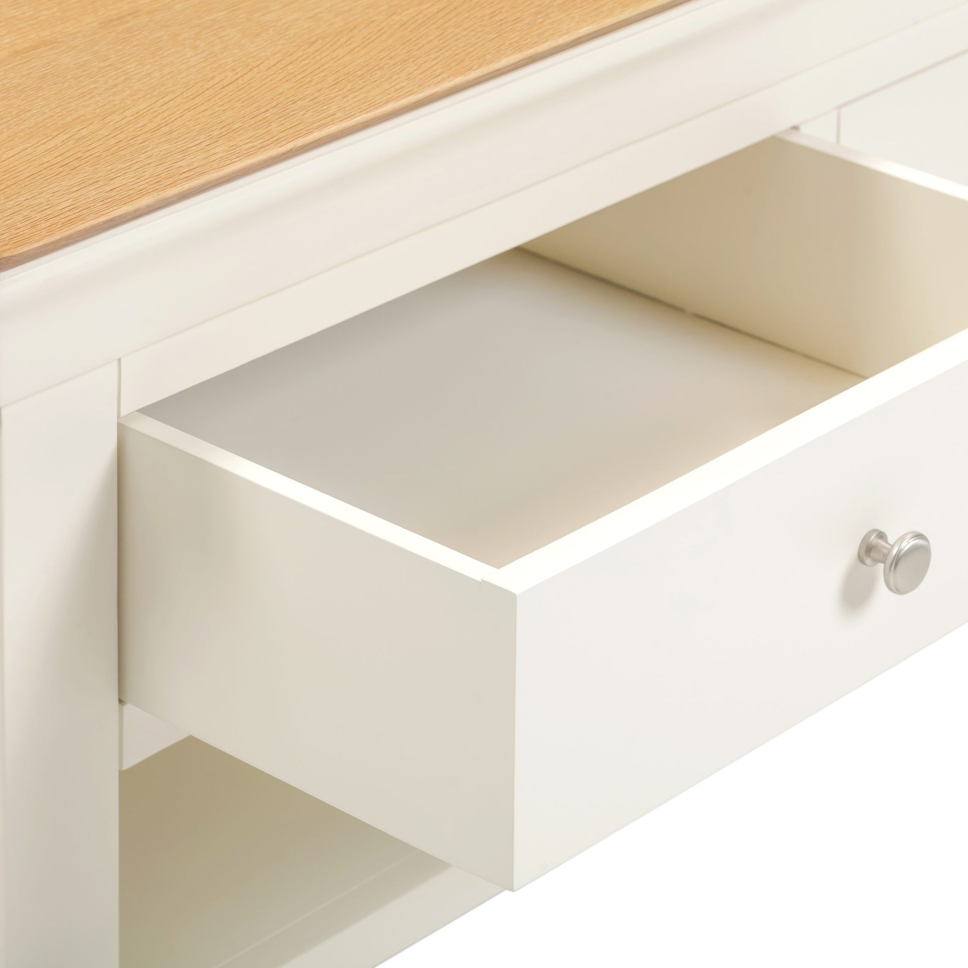 Open drawer of a white cabinet with a wooden top