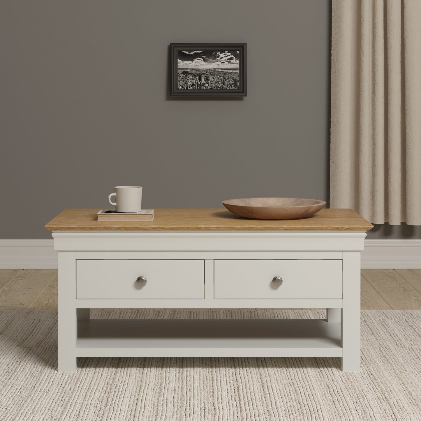 Coffee table with a white base and wooden top in a room with a gray wall and beige curtains.