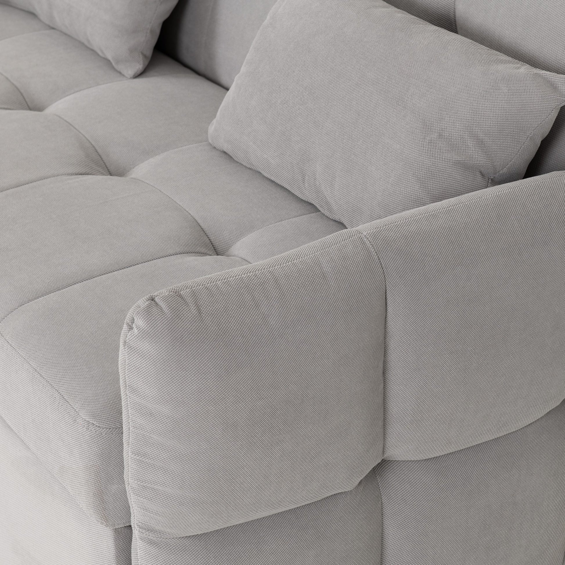 Gray sofa bed with tufted backrest and cushions