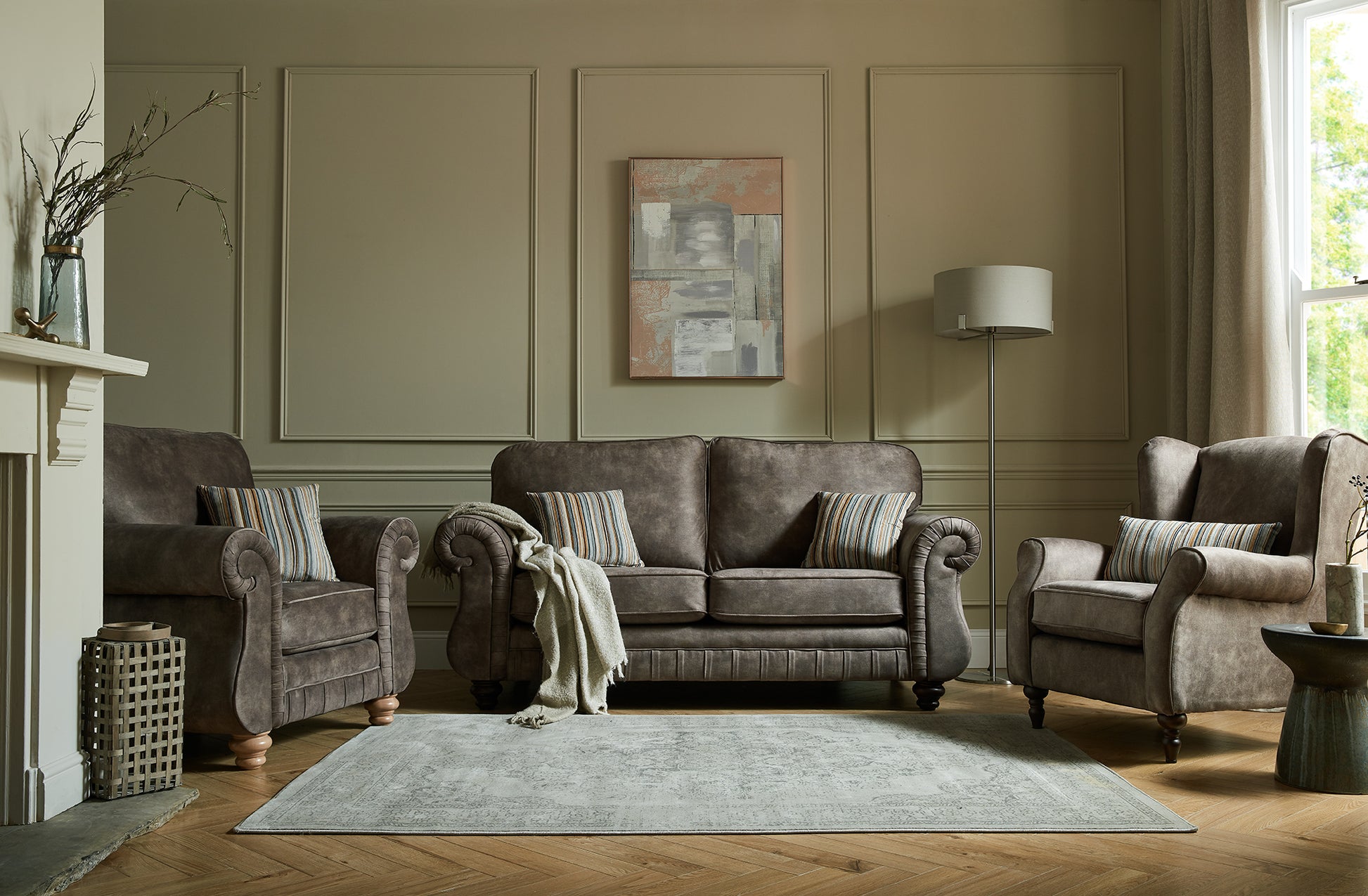 Living room with brown fabric sofa, armchairs, and a fireplace.