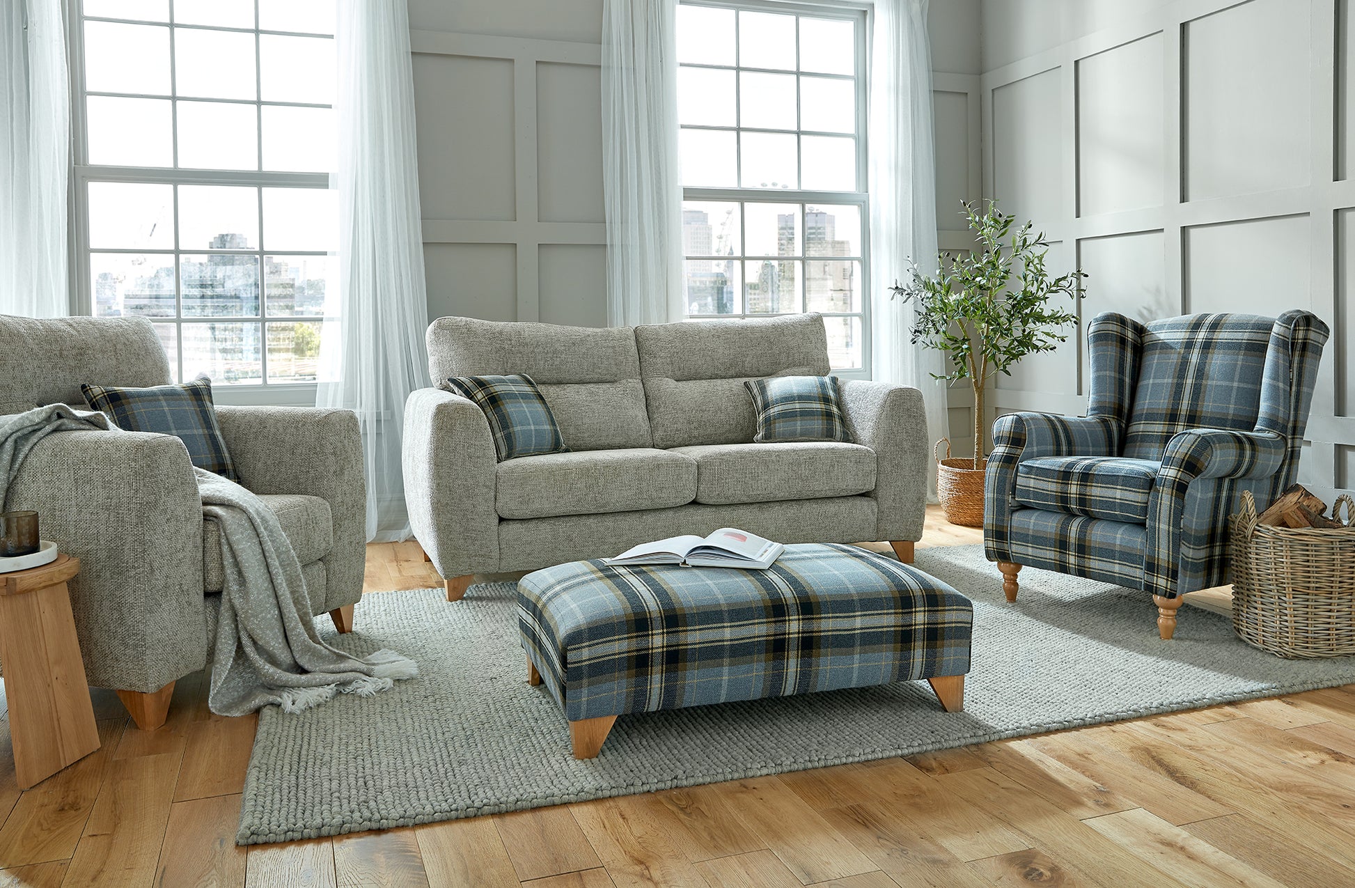 Living room with plaid furniture and large windows.