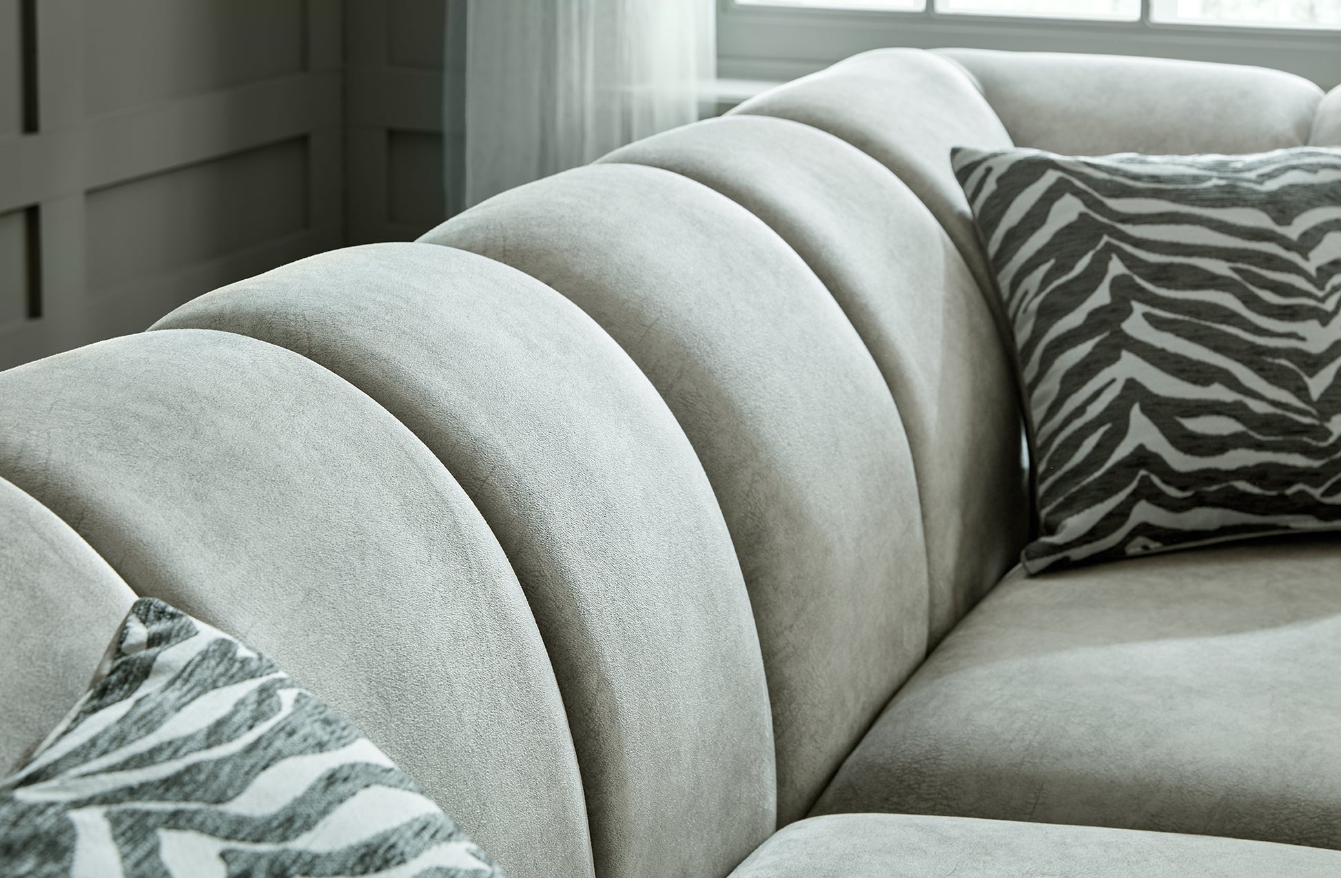Gray sofa with zebra print pillows in a room setting