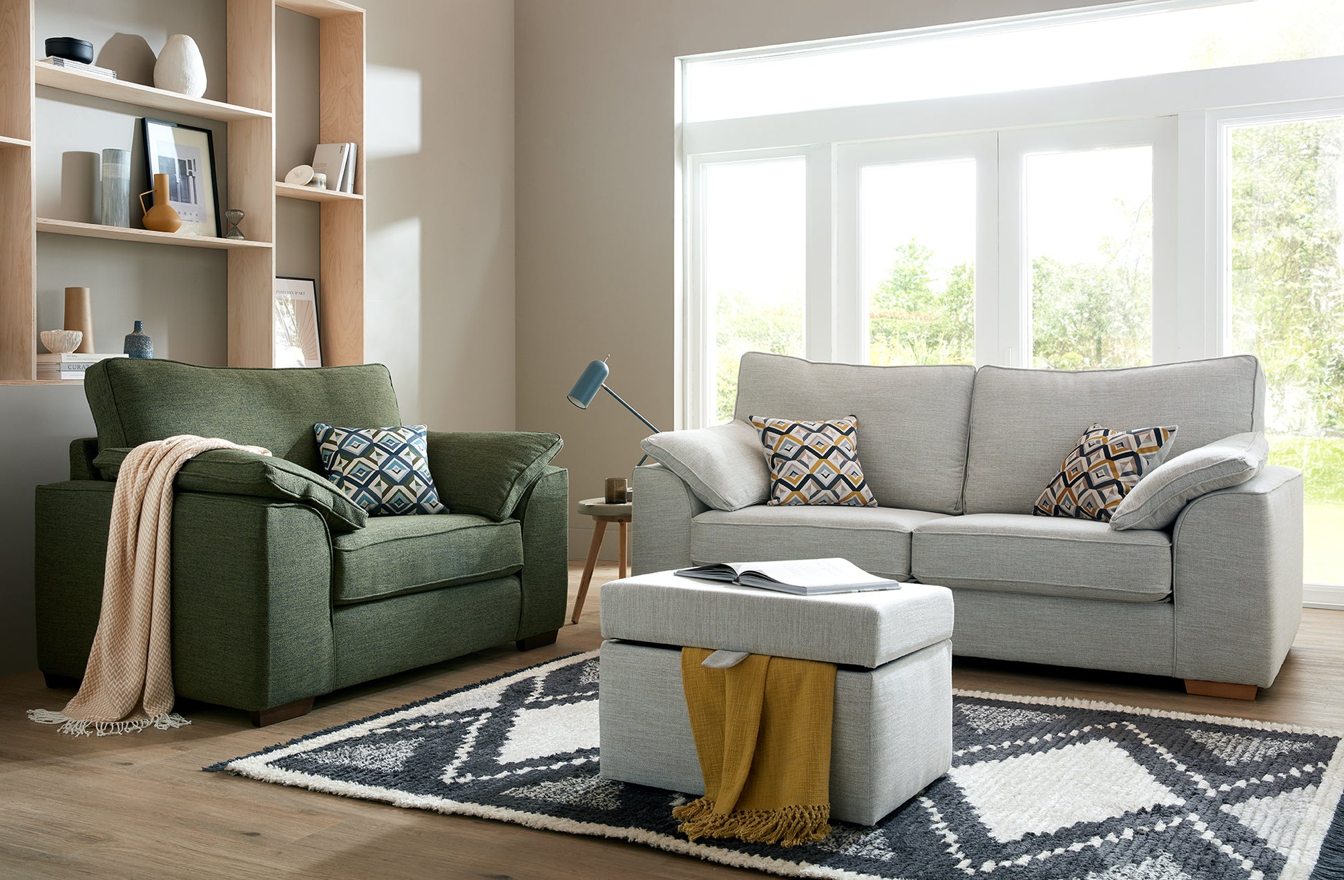 Living room with green armchair, grey fabric sofa, and ottoman.