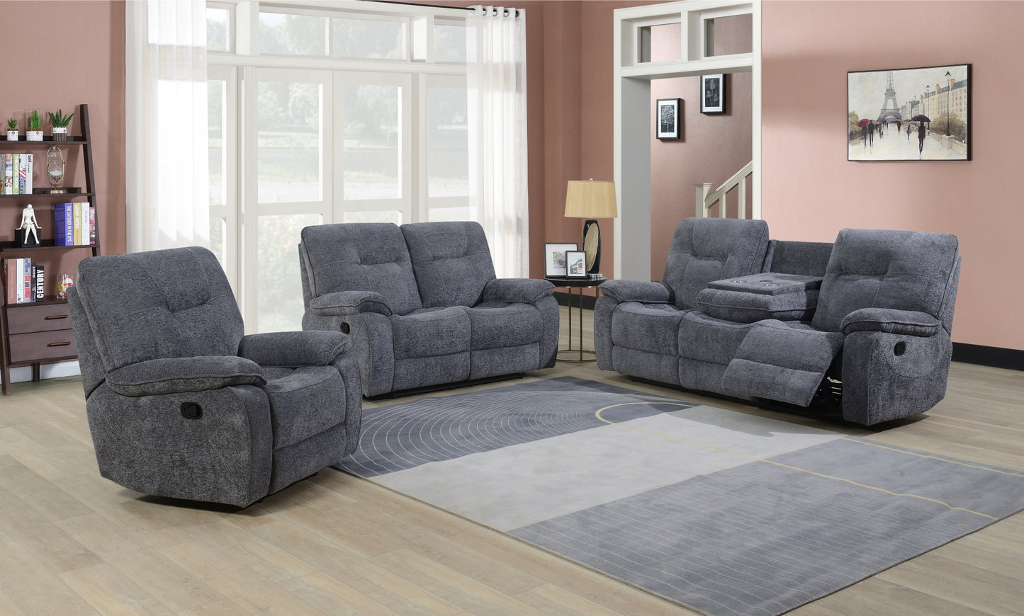 Gray fabric reclining sofa set in a living room with large windows and a rug.