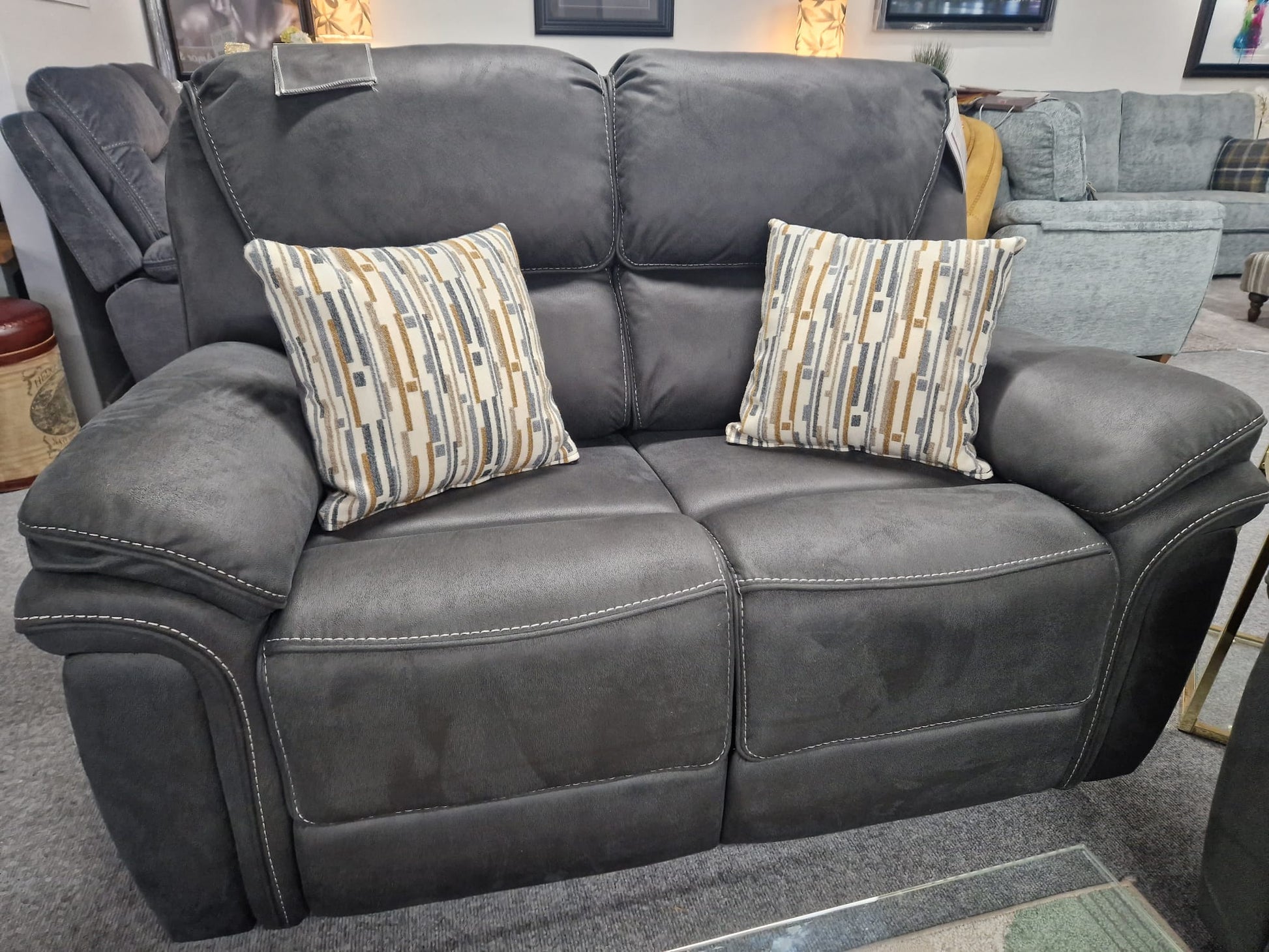 Slate Grey Fabric recliner sofa with patterned cushions in a room setting