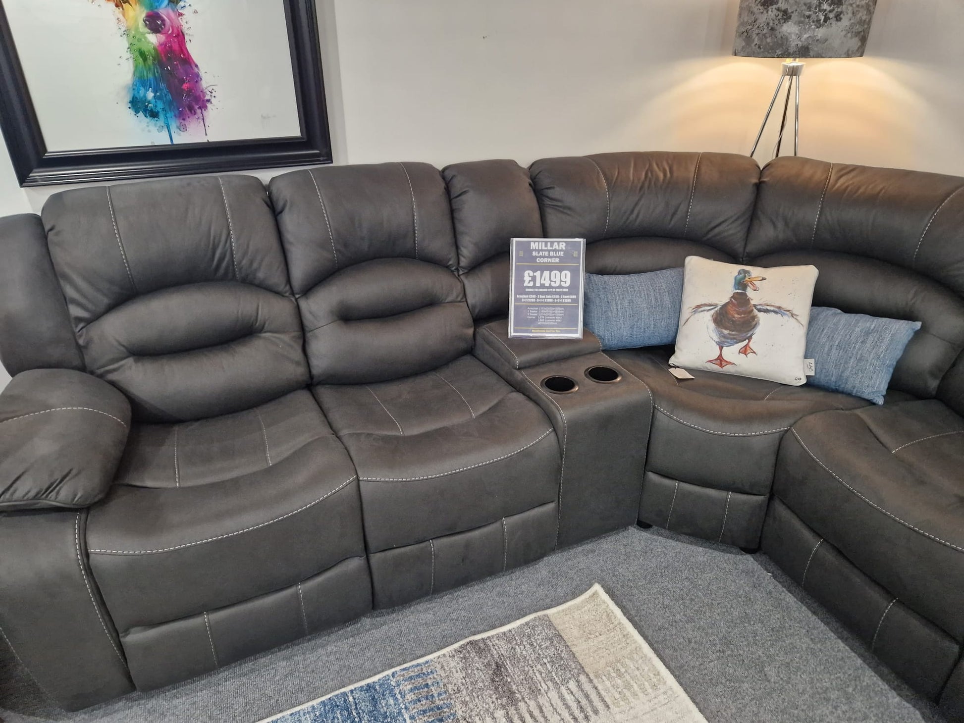 Gray sectional sofa with cushions and a small table in a living room setting.