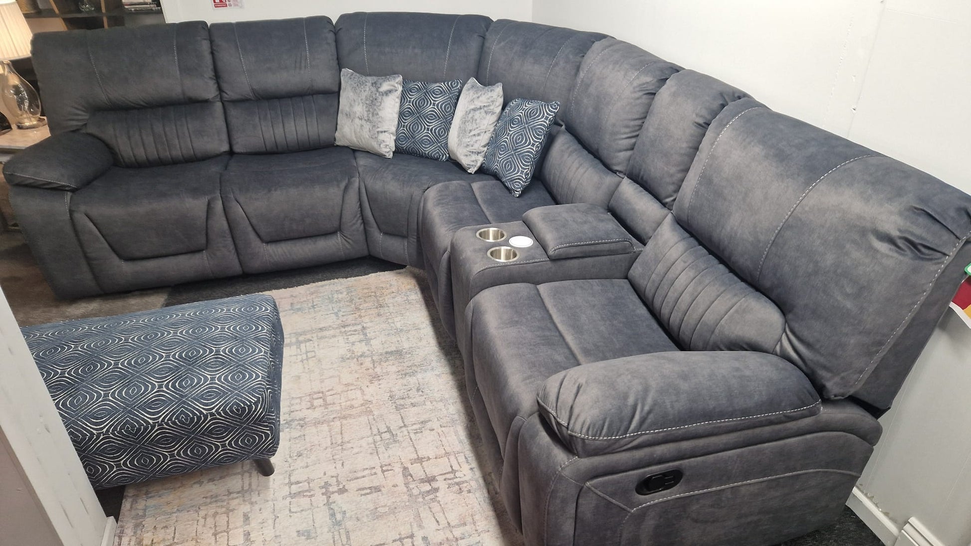 Gray sectional sofa with reclining seats in a living room setting.