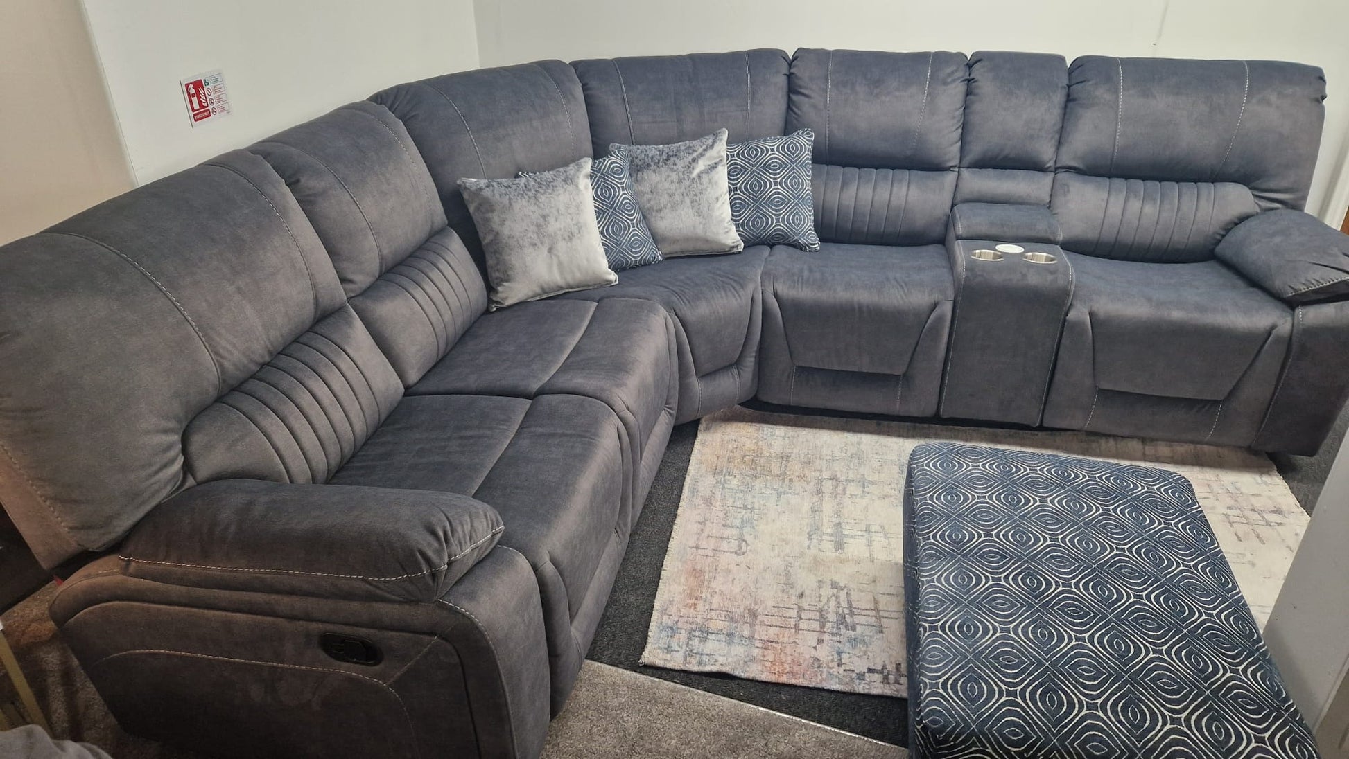 Dark Gray Fabric sectional reclining corner sofa with patterned cushions in a living room setting.