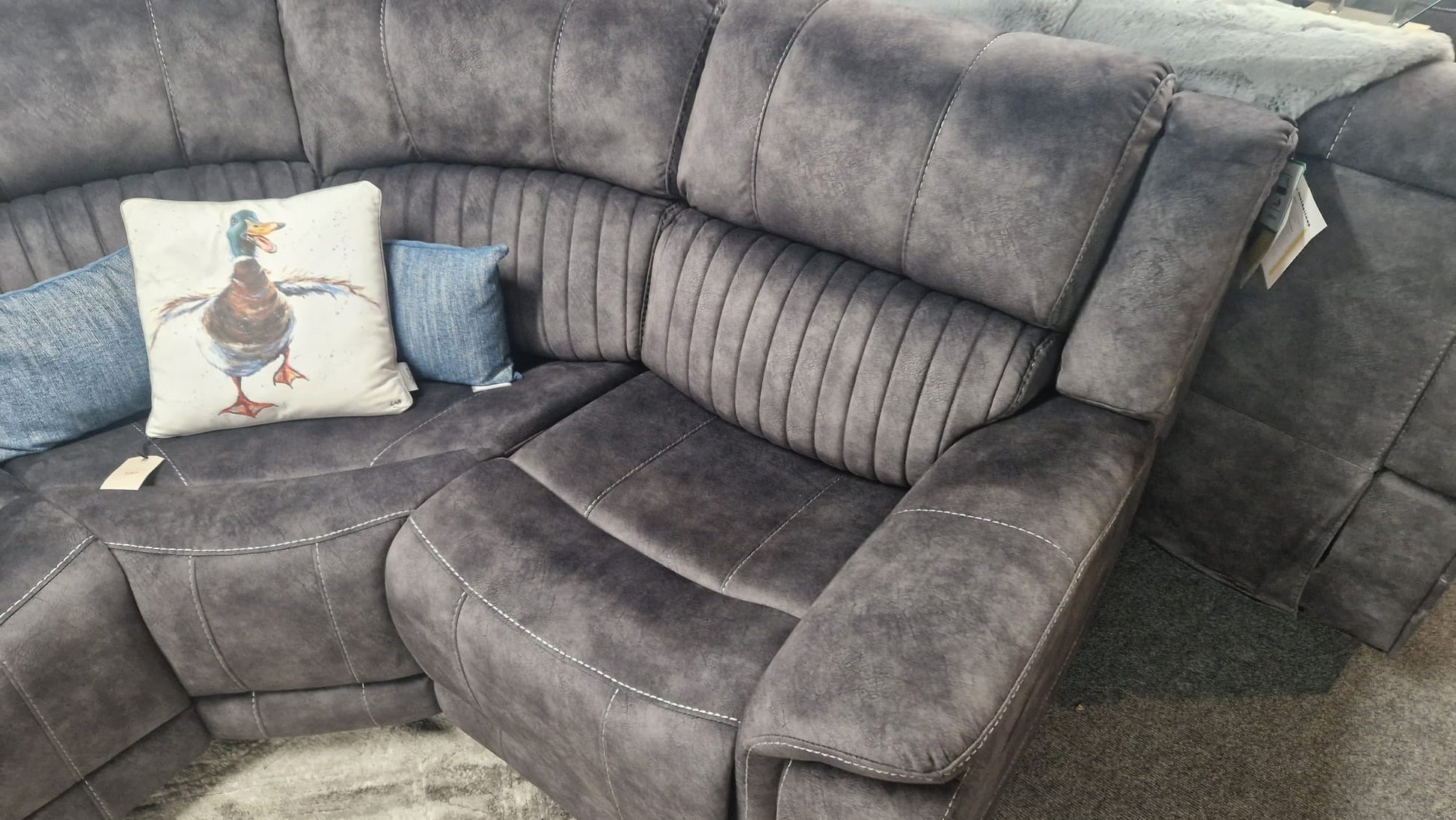 Dark Gray Fabric sectional reclining corner sofa with decorative pillows on a carpeted floor
