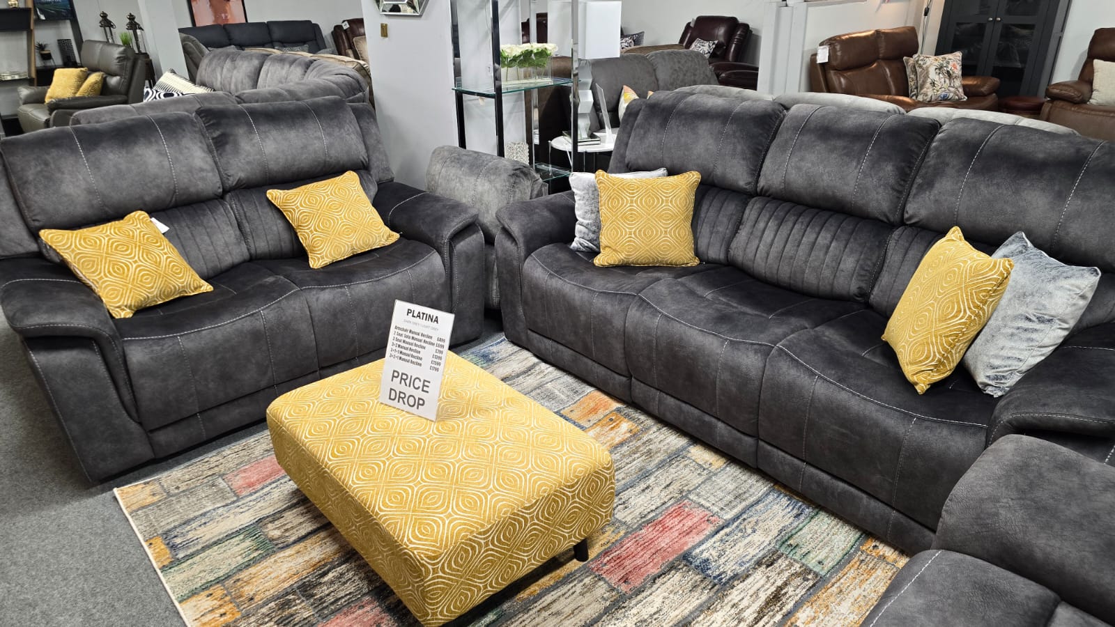 gray fabric power recliner with yellow cushions in a showroom setting
