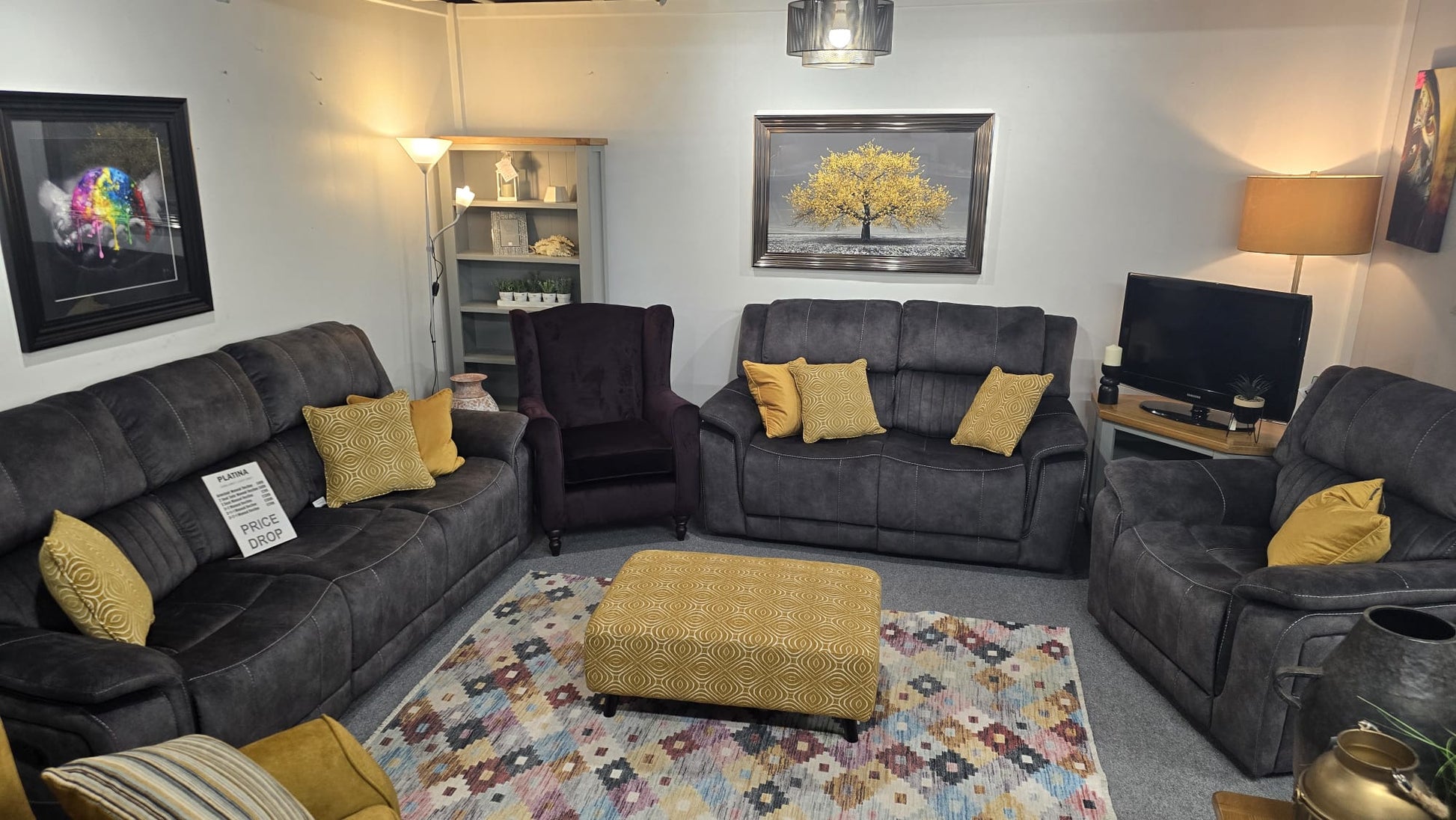 Living room with gray fabric power reclinera, armchair, and ottoman on a patterned rug.