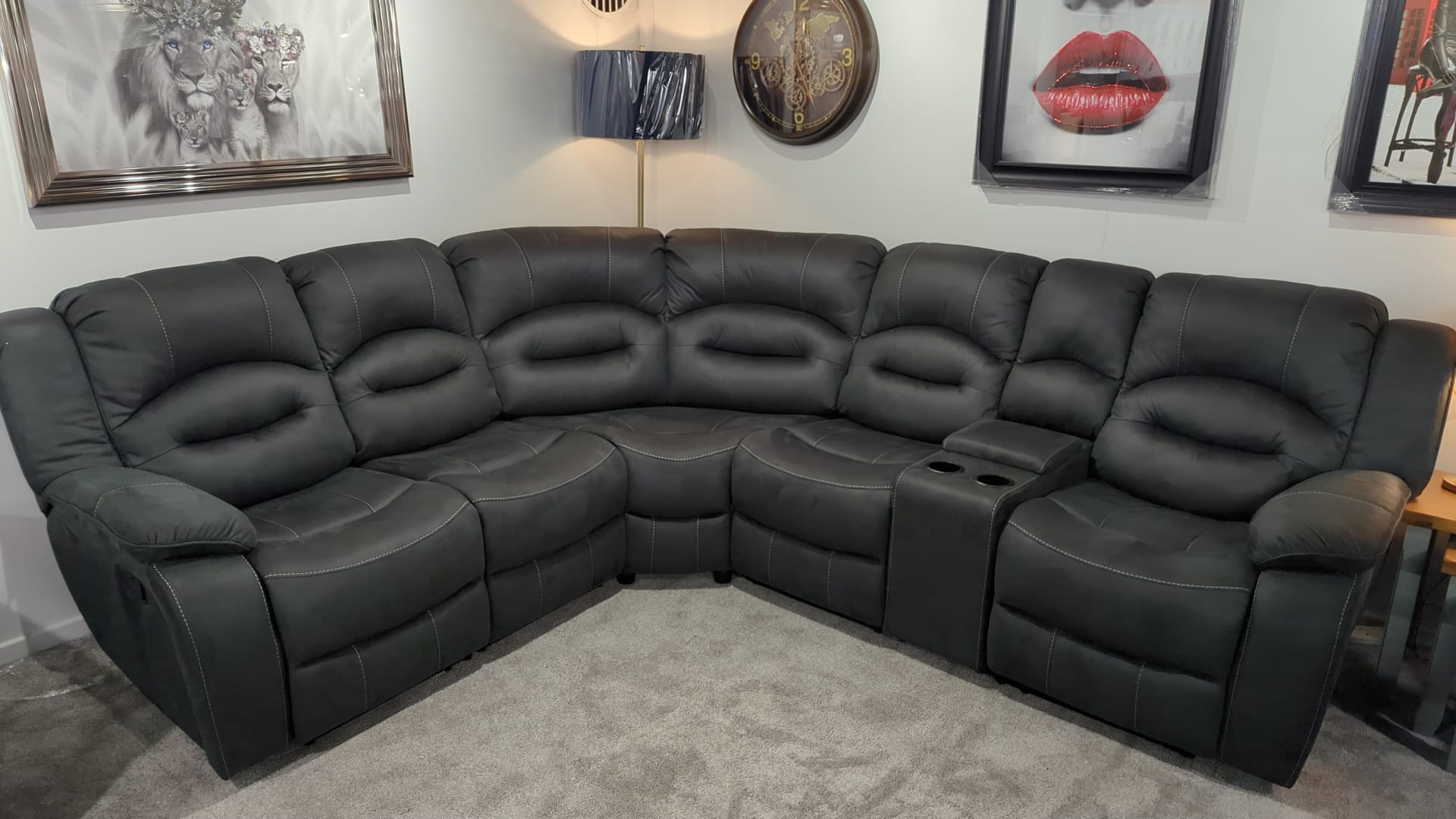 Slate Gray sectional recliner corner sofa in a living room setting with decorative items on the walls.