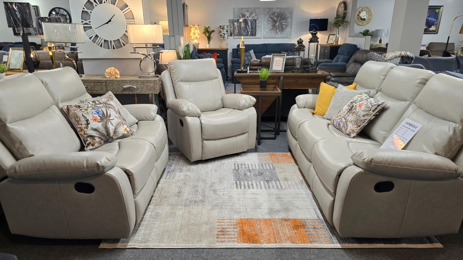 Living room with Light Beige leather recliner sofa, armchairs, and decorative pillows on a patterned rug.