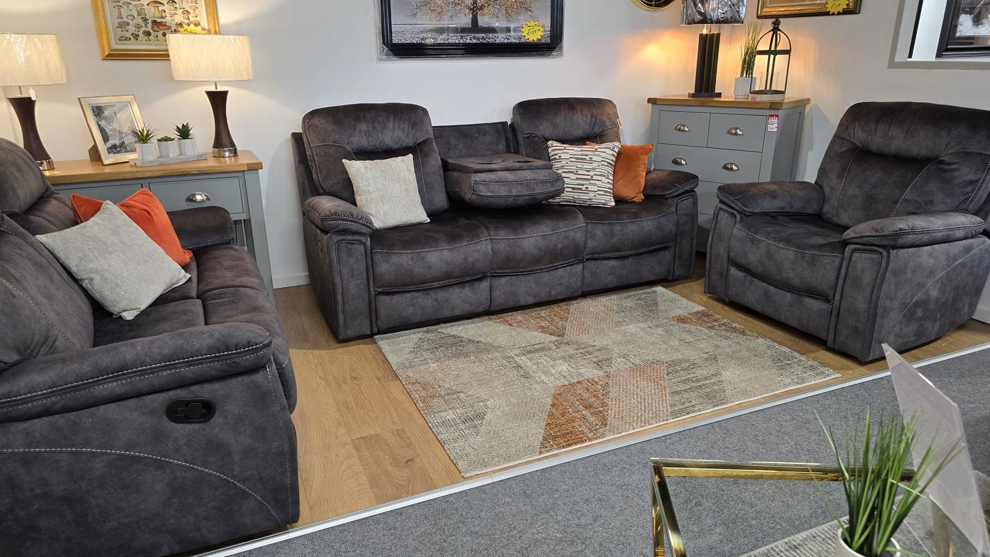 Dark Gray fabric recliner sofa set in a living room with decorative pillows and a rug.
