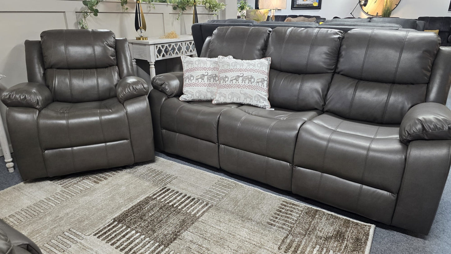 Gray leather sectional sofa with a pillow on a carpeted floor