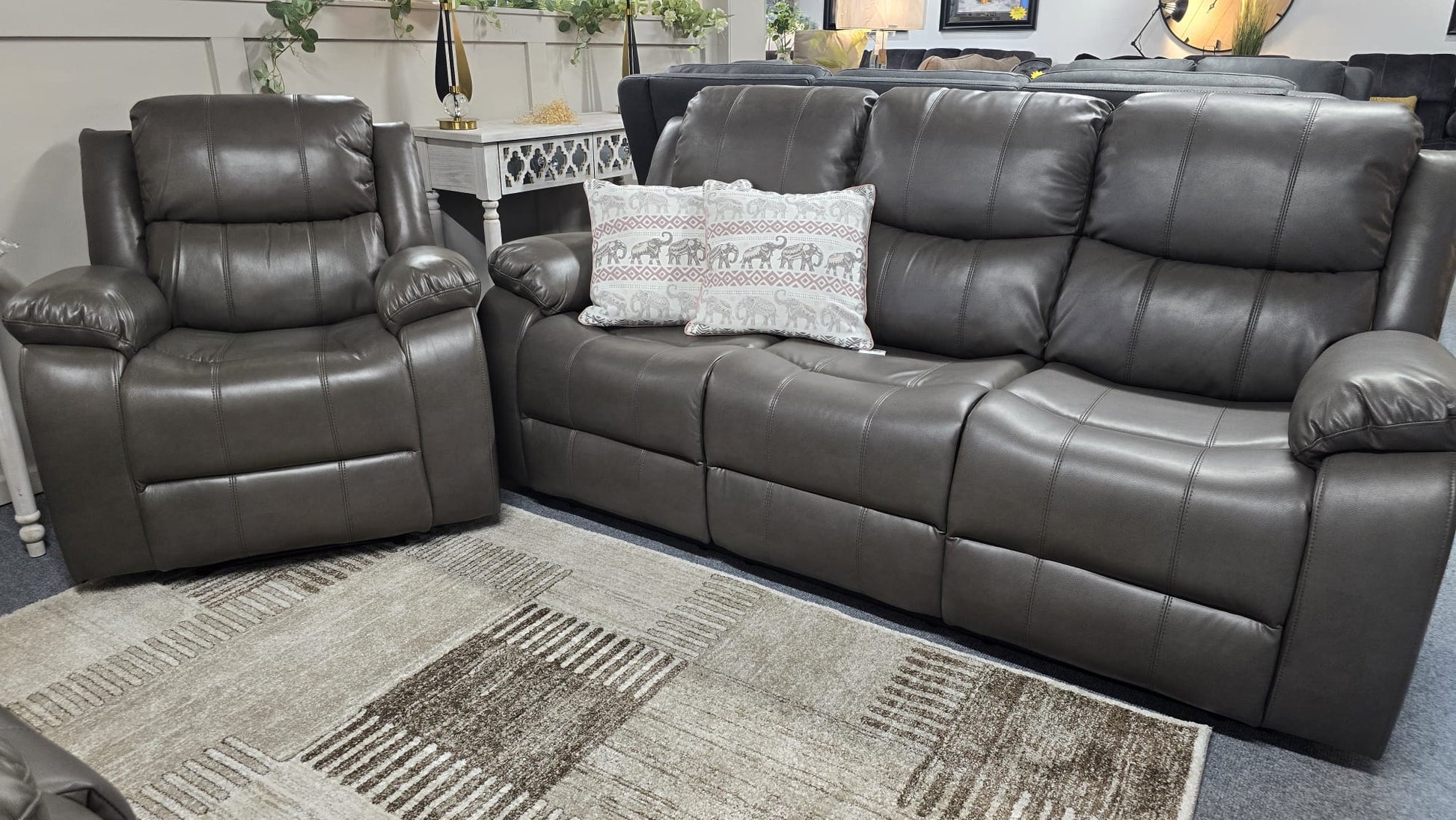 Gray leather sectional sofa with a pillow on a carpeted floor