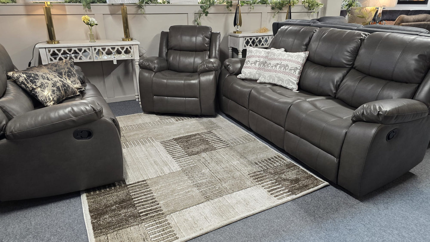 Gray leather recliner sofa set in a living room setting with decorative pillows and a rug.