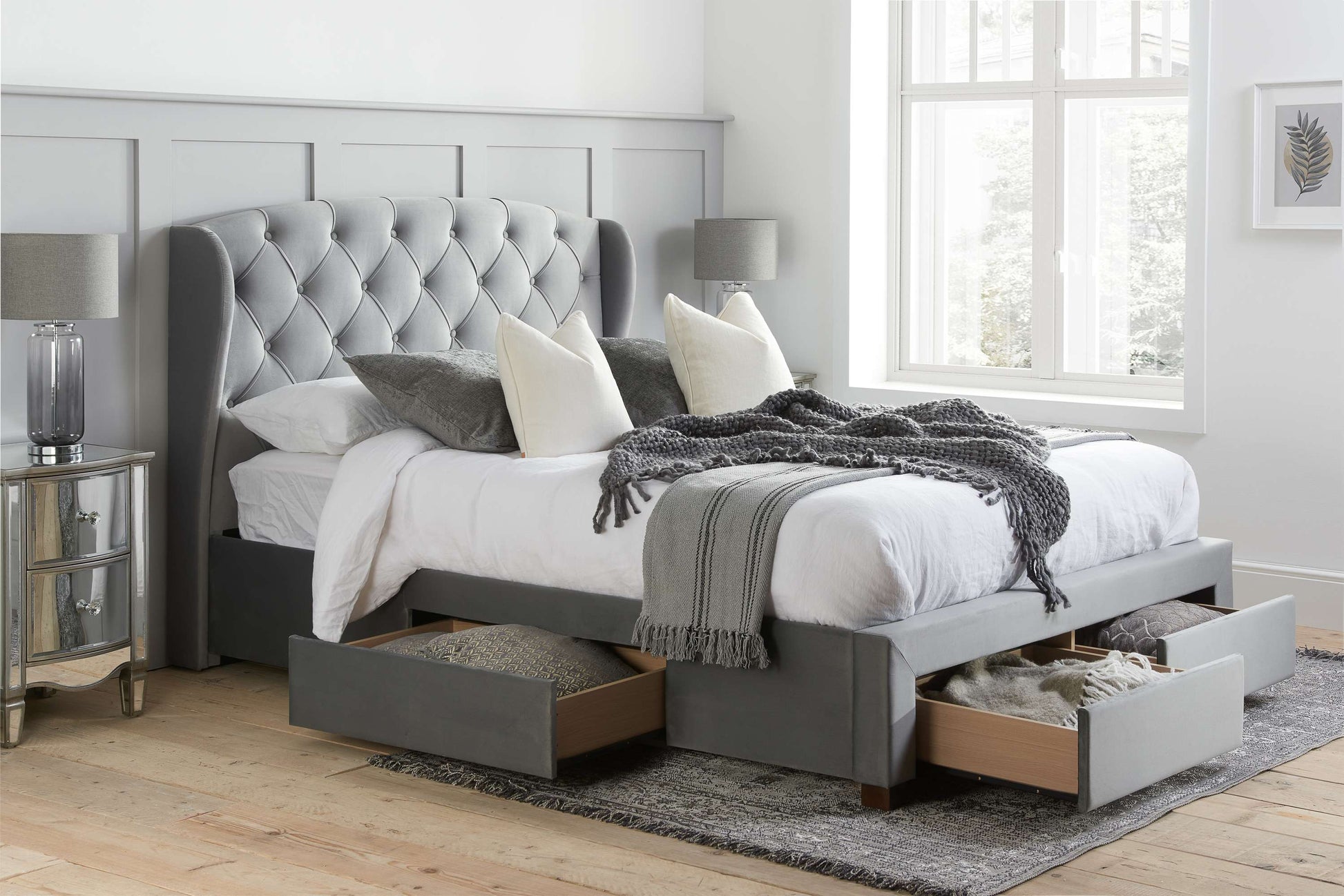 Gray upholstered bed with storage drawers in a bedroom setting