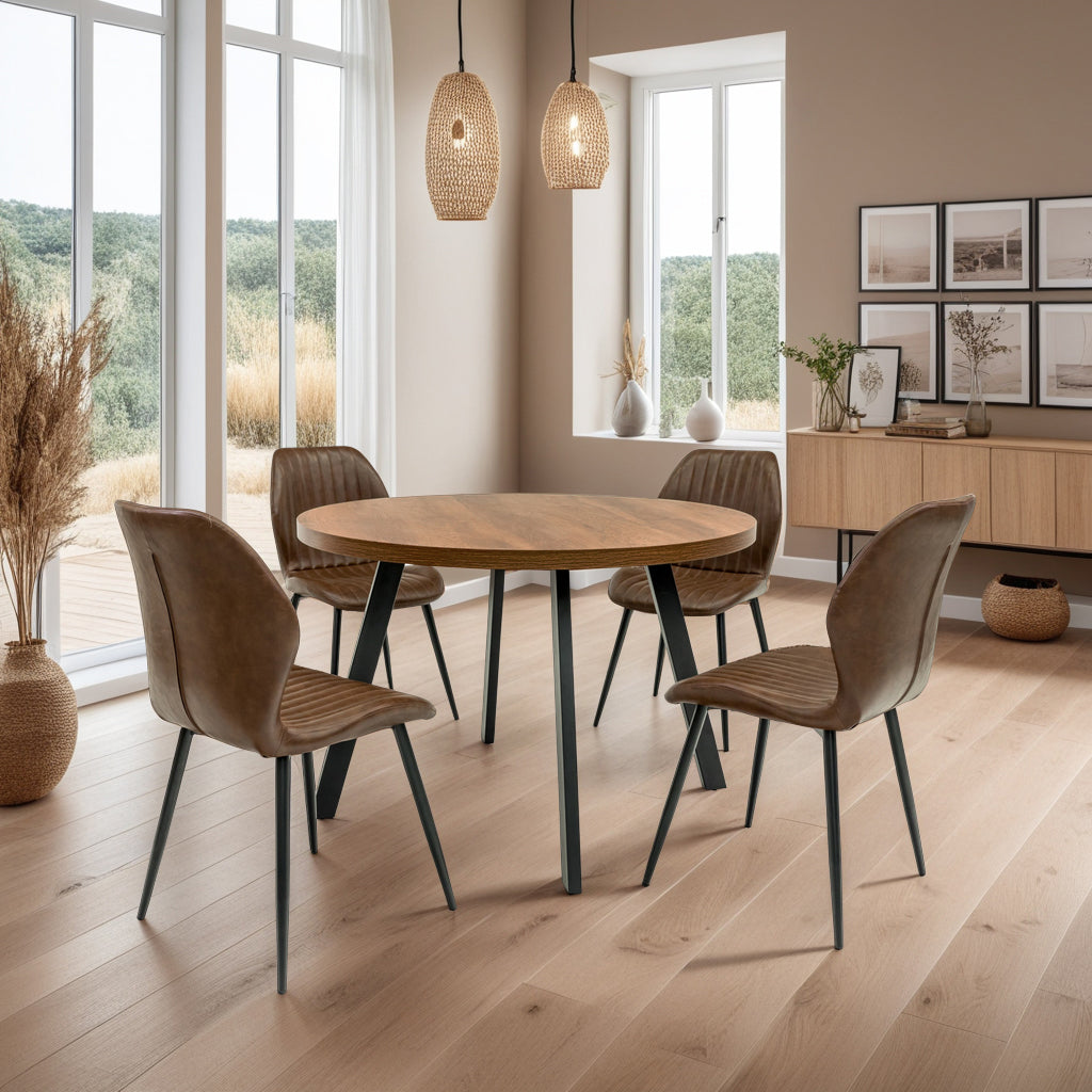 Dining room with a round wooden table and four chairs in a well-lit room with large windows.
